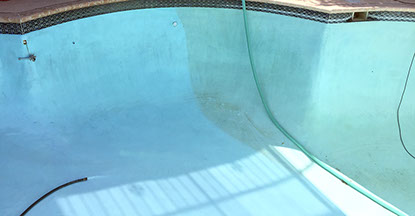 Painted blue pool with algae