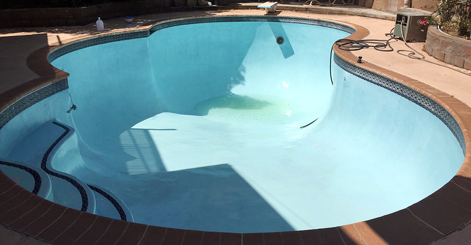 Painted blue pool with algae in process of an acid wash